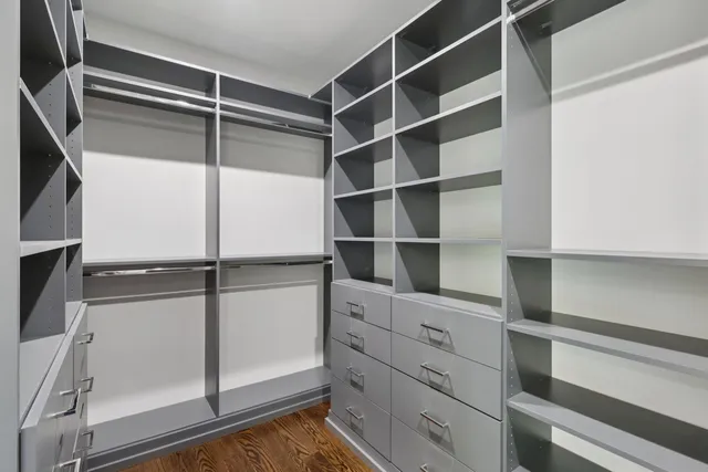 a view of walk in closet with empty racks