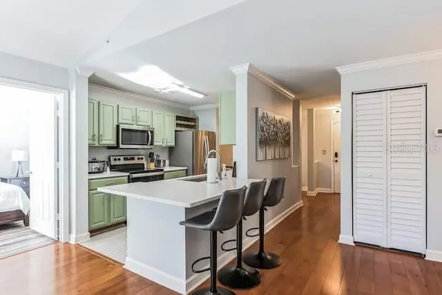 a kitchen with a table chairs refrigerator and microwave