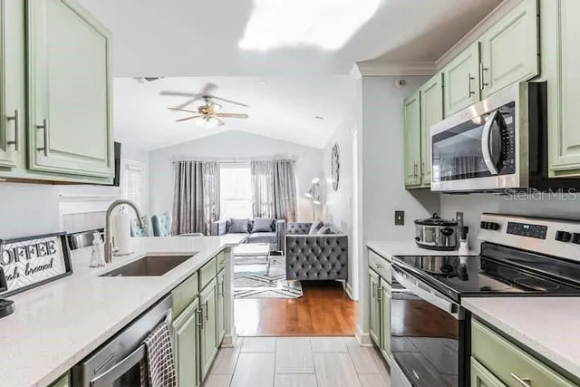 a kitchen with stainless steel appliances a sink dishwasher stove refrigerator and microwave