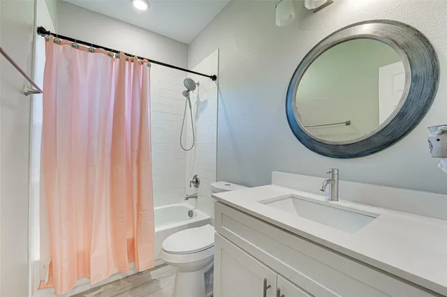 a bath room with a sink a toilet and a mirror