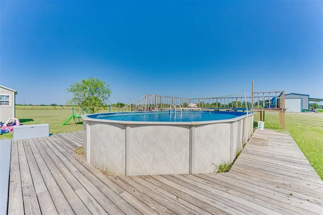 a view of a swimming pool with a lawn chairs under an umbrella