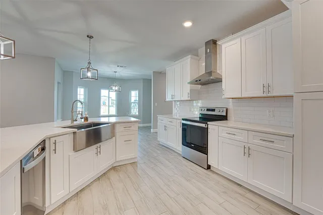 a large white kitchen with cabinets and stainless steel appliances