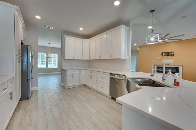 a kitchen that has a lot of cabinets a sink and appliances in it