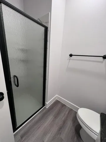 a bathroom with a white toilet and shower