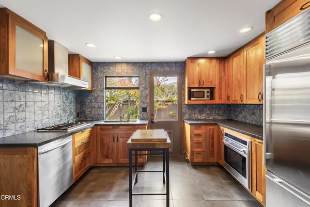 a kitchen with stainless steel appliances granite countertop sink stove top oven and cabinets
