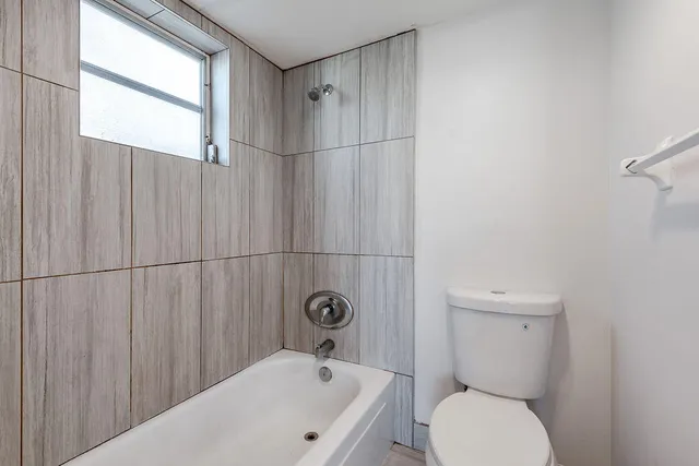 a bathroom with a toilet a sink and shower