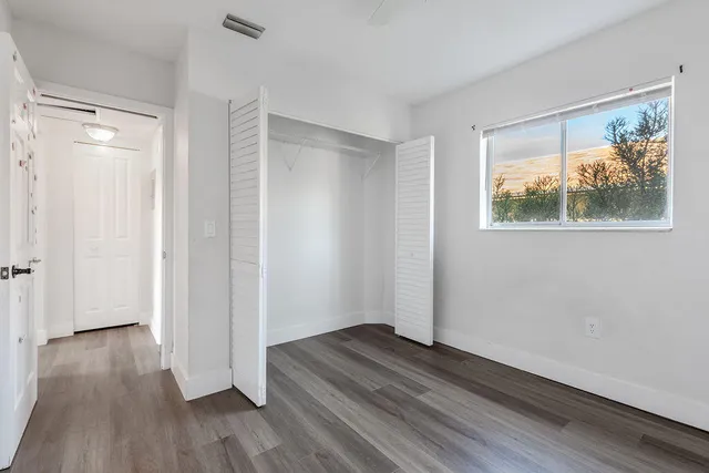 a view of a room with wooden floor closet and a window