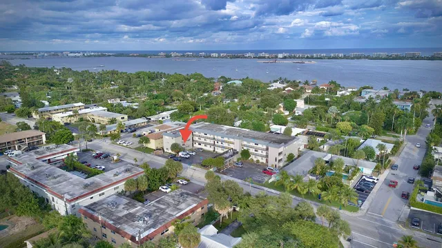 an aerial view of a city with lots of residential buildings ocean and mountain view in back