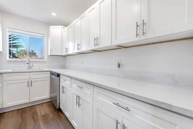 a kitchen with stainless steel appliances white cabinets and a sink