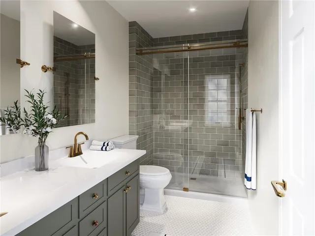 a bathroom with a shower sink vanity mirror and toilet