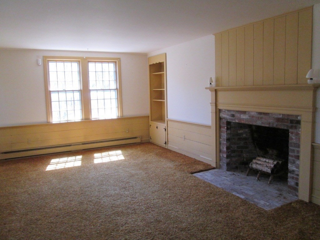 66 Westcott Road Harvard, MA 01451 - Photo 10 of 38 a view of an empty room with a fireplace and a window
