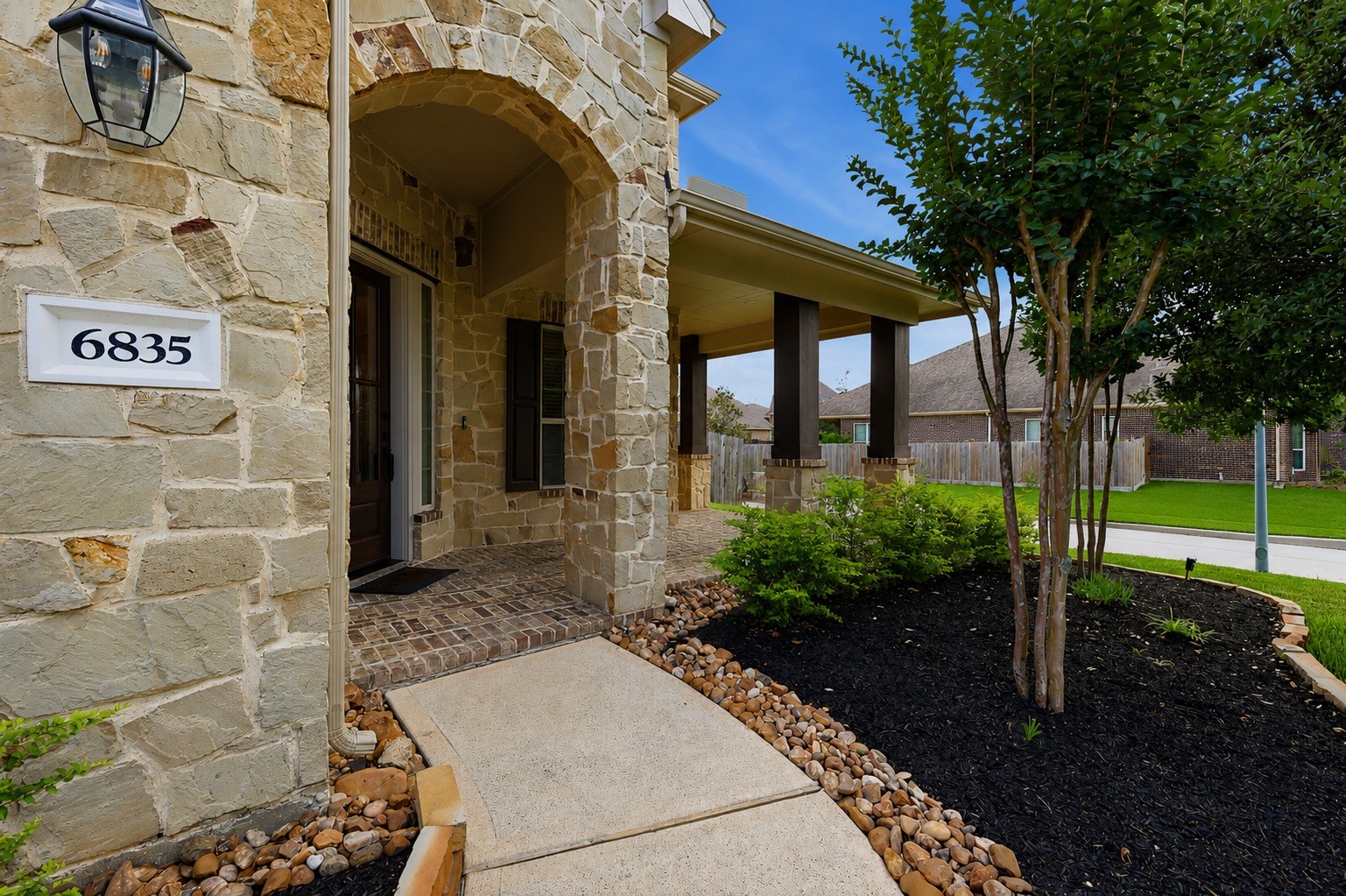 6835 Preston Grove Drive Spring, TX 77389 - Photo 6 of 49 a view of a brick house with a small yard plants and large tree