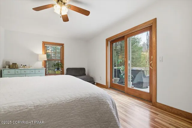 a view of empty room with wooden floor and ceiling fan