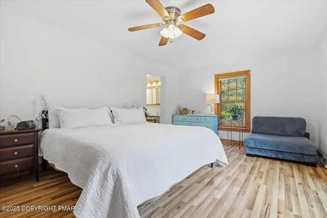 a view of an empty room with wooden floor fireplace and a window