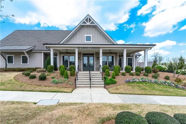 a front view of a house with garden and seating