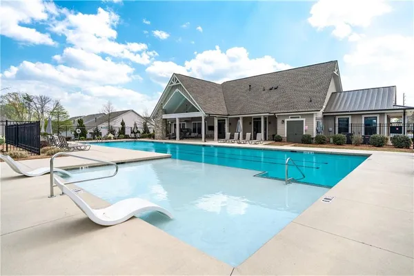 a view of a house with swimming pool and sitting area