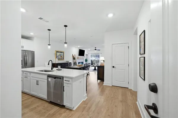 a kitchen with a sink stainless steel appliances and white cabinets