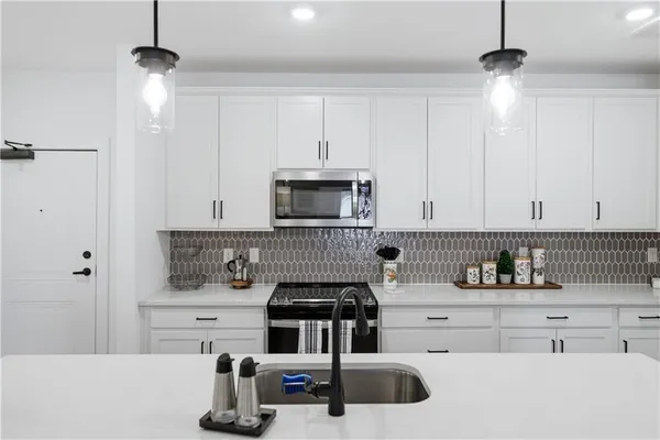 a kitchen with kitchen island a sink stainless steel appliances and cabinets