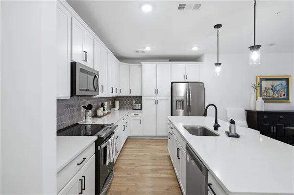 a kitchen with stainless steel appliances granite countertop a sink stove and refrigerator