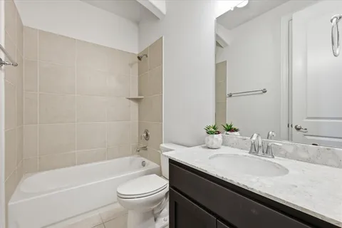 a bathroom with a granite countertop sink a toilet and shower