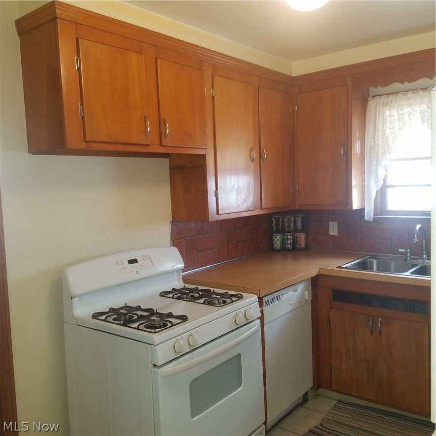 5820 Dunham Road Maple Heights, OH 44137 - Photo 14 of 35 Wood kitchen cabinets, gas stove, and window above the sink