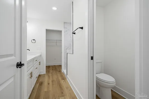 a bathroom with a granite countertop shower a toilet and a sink