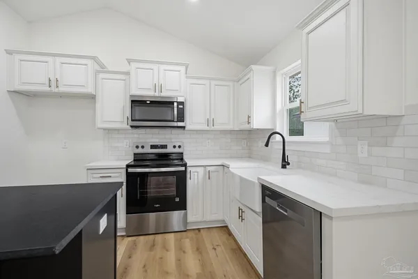 a kitchen with stainless steel appliances granite countertop a stove a sink and a microwave