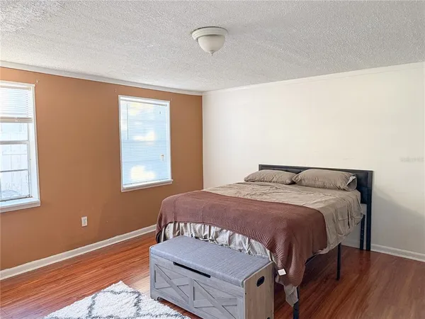 a bedroom with a bed and wooden floor