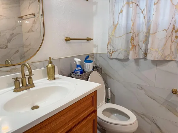 a bathroom with a sink a toilet and a mirror