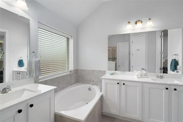 a bathroom with a tub a sink and a window