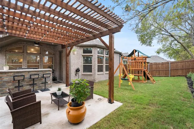 a view of a backyard with potted plants and a wooden bench