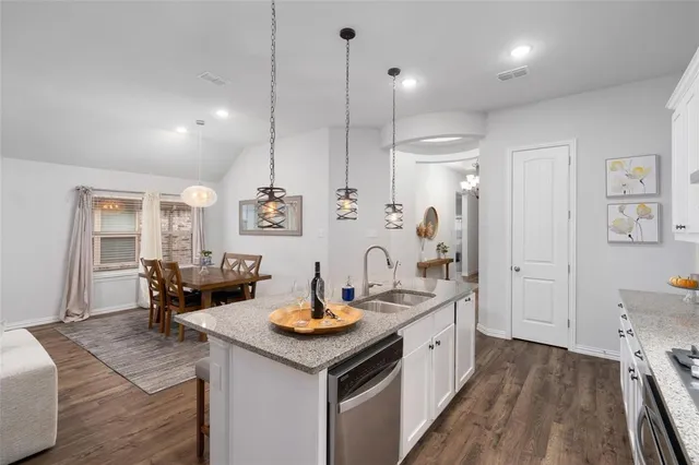 a kitchen with a sink stove and wooden floor