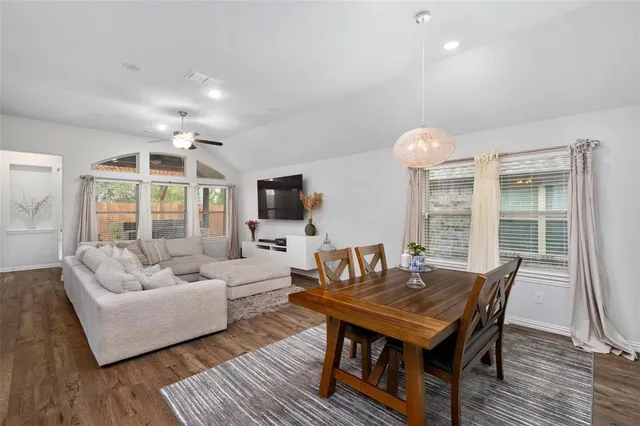 a living room with furniture a flat screen tv and a large window