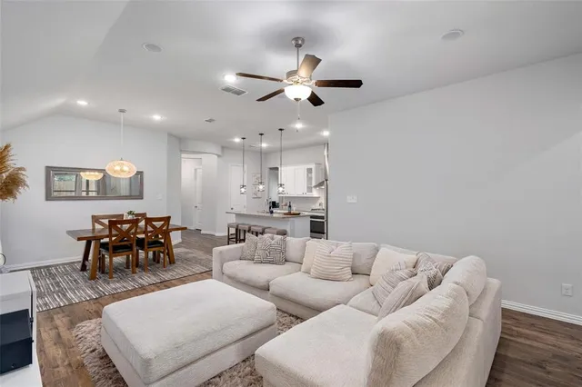 a living room with furniture and a dining table with kitchen view