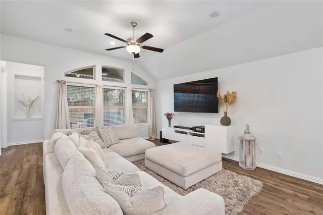 a living room with furniture a flat screen tv and a window