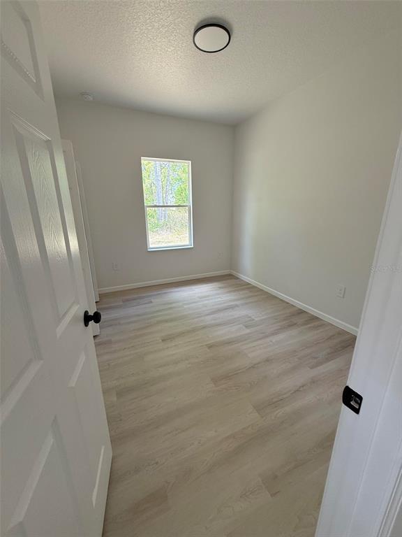 14685 Southwest 22nd Place Ocala, FL 34481 - Photo 11 of 13 wooden floor in an empty room with a window