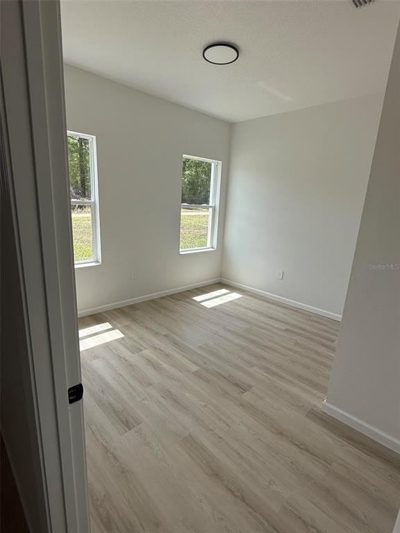 14685 Southwest 22nd Place Ocala, FL 34481 - Photo 12 of 13 an empty room with wooden floor and windows