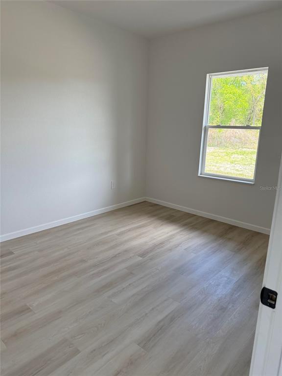 14685 Southwest 22nd Place Ocala, FL 34481 - Photo 7 of 13 an empty room with wooden floor and a window