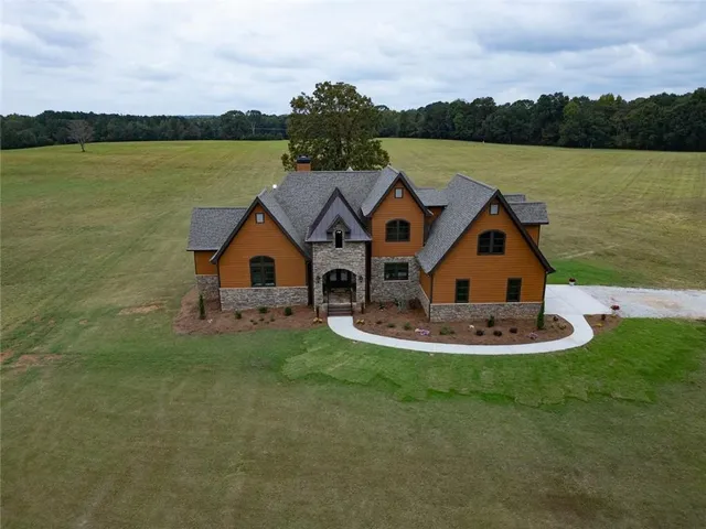 a aerial view of a house with a yard and lake view