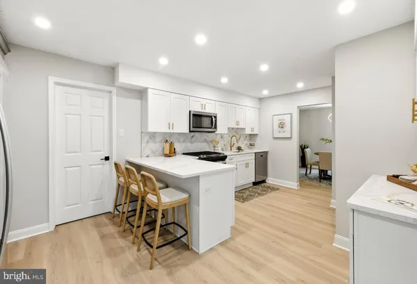 a kitchen with a dining table chairs refrigerator and cabinets