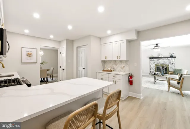 a kitchen with kitchen island a stove a sink a refrigerator and cabinets