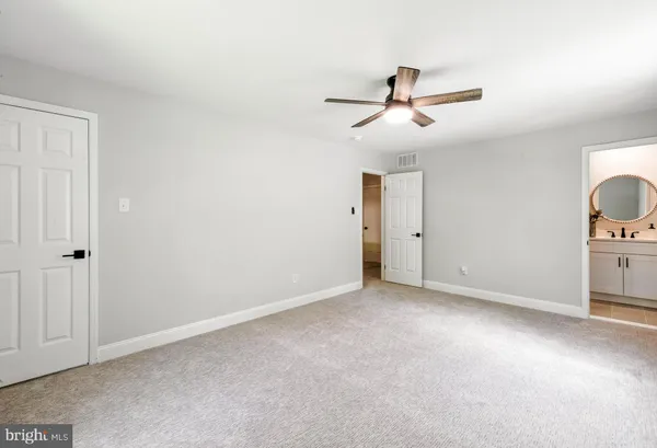 an empty room with closet and fan