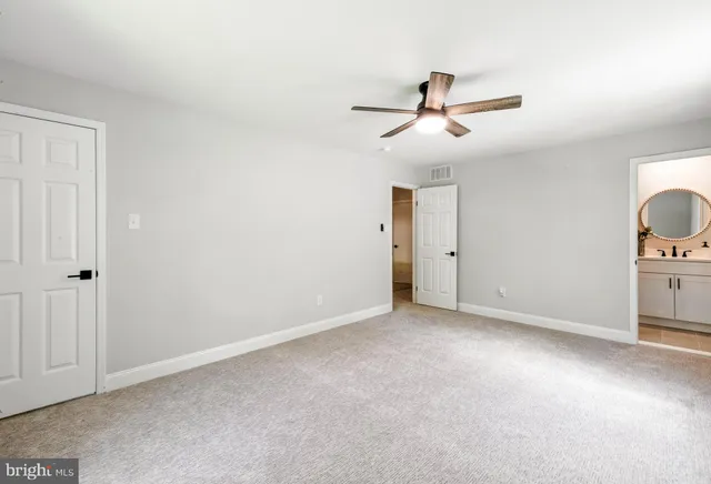 an empty room with closet and fan