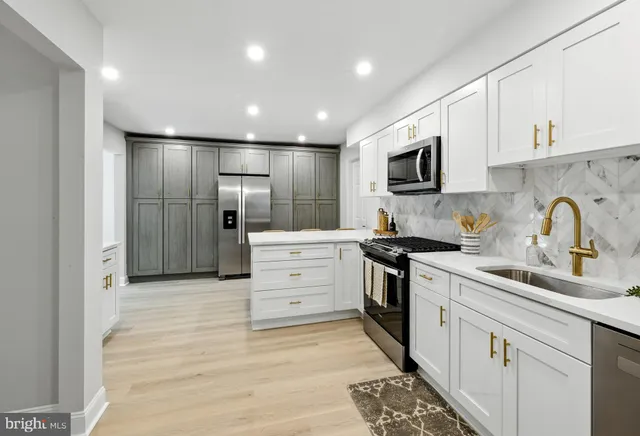 a kitchen with white cabinets and stainless steel appliances