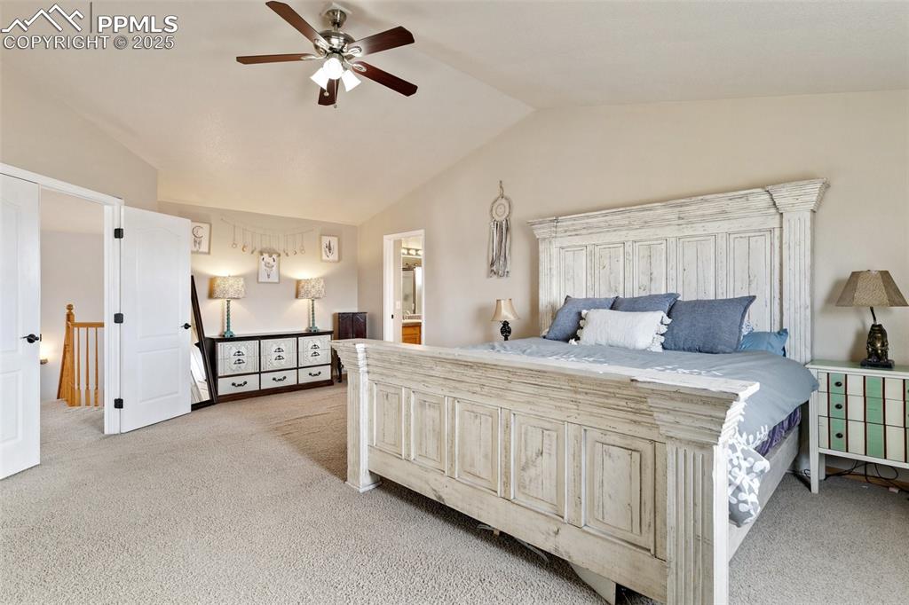 8518 Bohleen Road Peyton, CO 80831 - Photo 17 of 44 a spacious bedroom with a bed a lamp and a chandelier