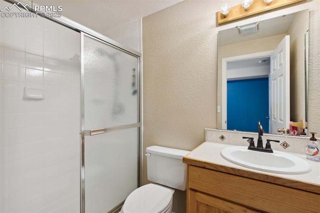 8518 Bohleen Road Peyton, CO 80831 - Photo 34 of 44 a bathroom with a sink toilet vanity and shower