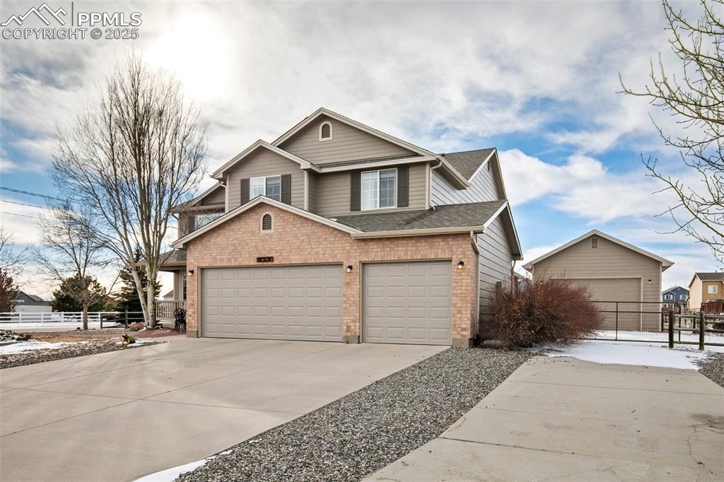 8518 Bohleen Road Peyton, CO 80831 - Photo 4 of 44 a front view of a house with a yard and garage
