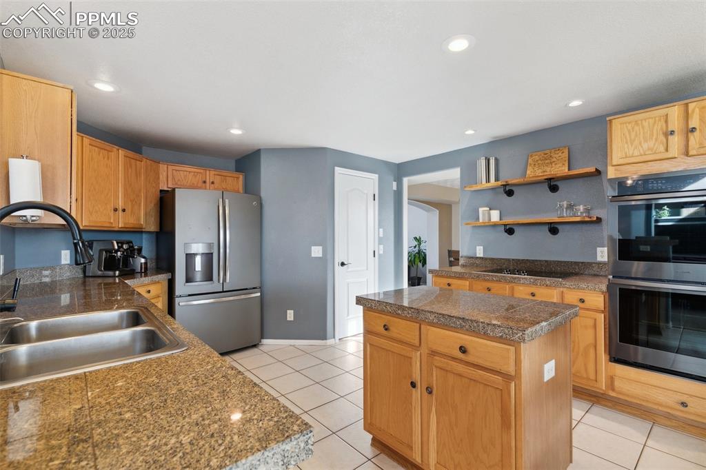 8518 Bohleen Road Peyton, CO 80831 - Photo 7 of 44 a kitchen with stainless steel appliances granite countertop a sink stove and refrigerator
