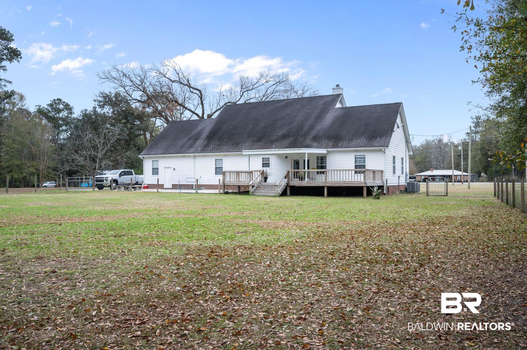 9539 Lakeview Road Bay Minette, AL 36507 - Photo 32 of 45 Back of property with central air condition unit, a yard, and a deck