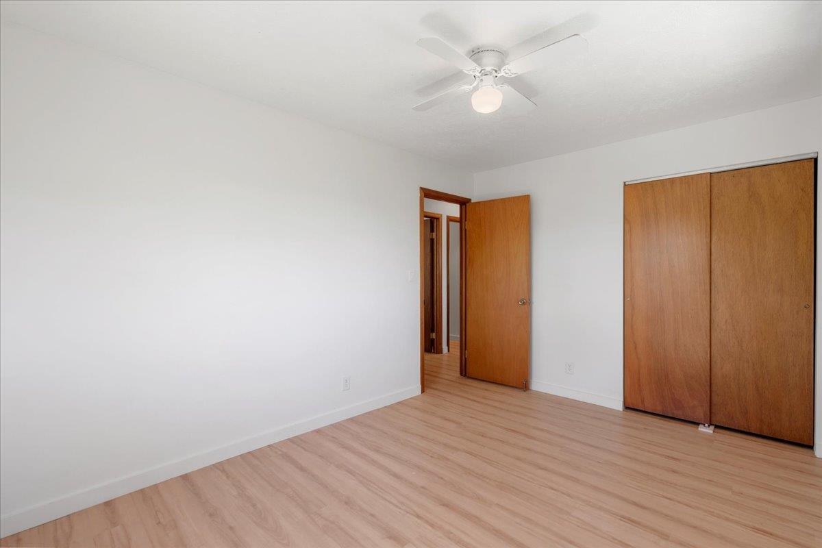 2130 Kauhikoa Road, Unit A Haiku, HI 96708 - Photo 28 of 43 an empty room with wooden floor and ceiling fan